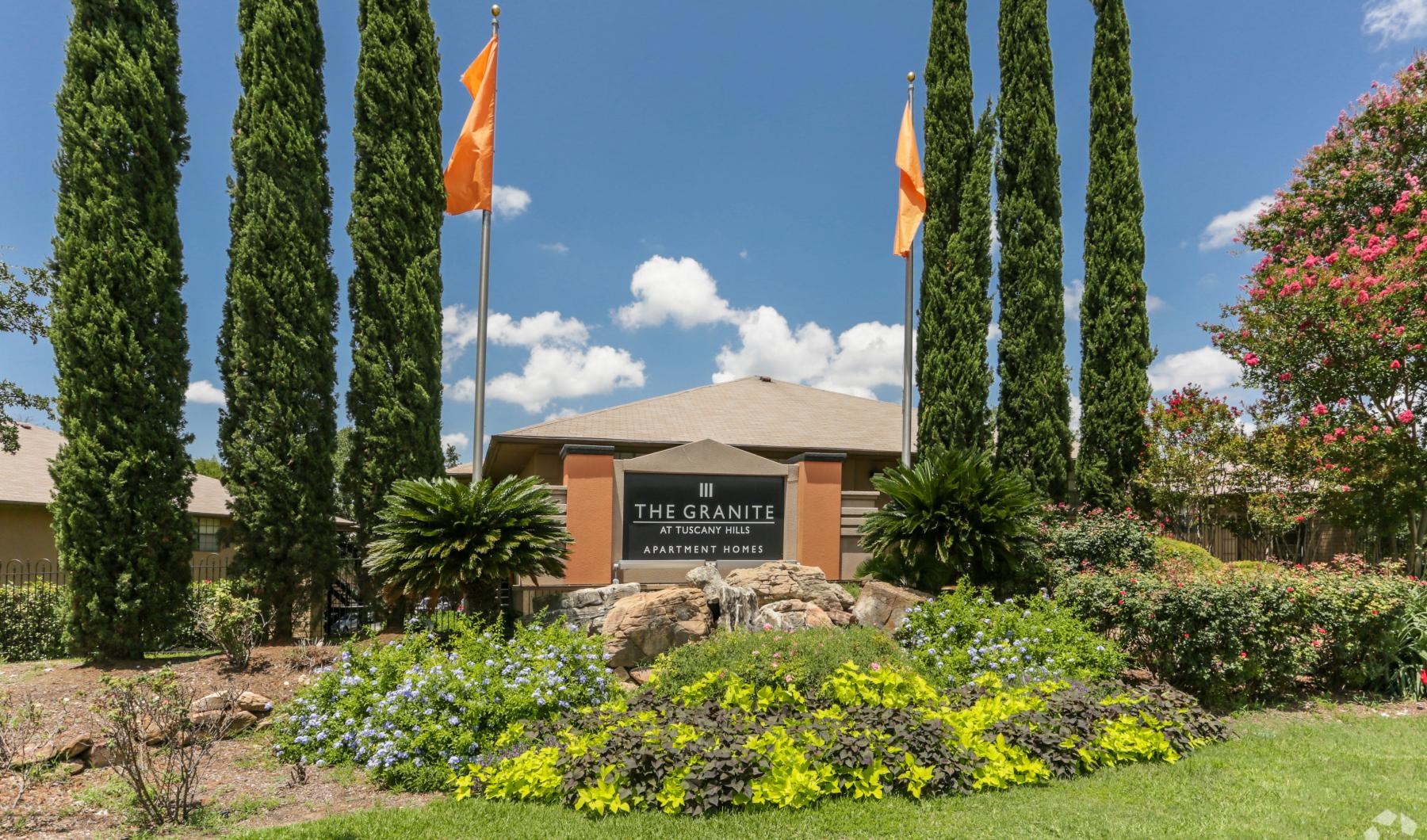 a building with flags and trees in the front